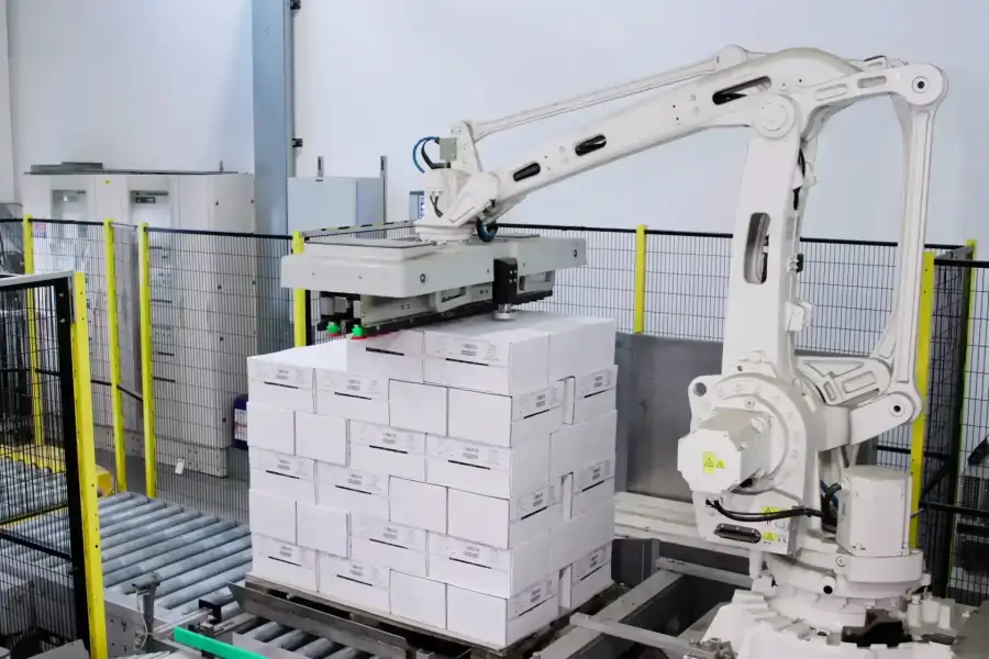 Braccio robotico automatizzato organizza scatole di caffè prima di essere depositate nei magazzini