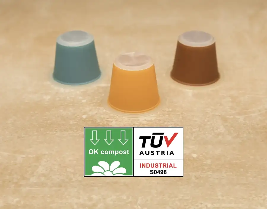 Foto di capsule Nespresso in materiale compostabile con logo Ok Compost TUV Austria