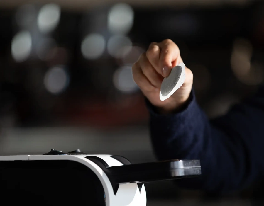 Mano inserisce una cialda ESE in una macchina del caffè